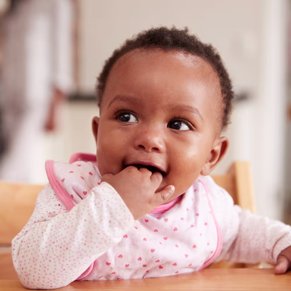 Feeding schedule by age - baby in high chair ready to eat
