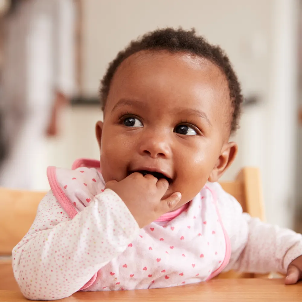 Feeding schedule by age - baby in high chair ready to eat