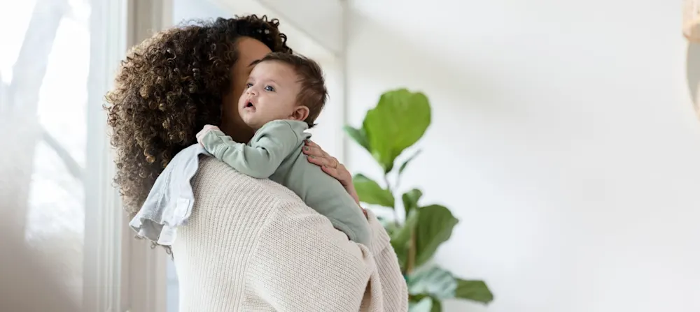 A woman burping a baby.