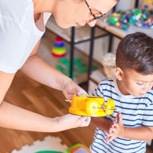 A mother showing a toddler clock to her child. 