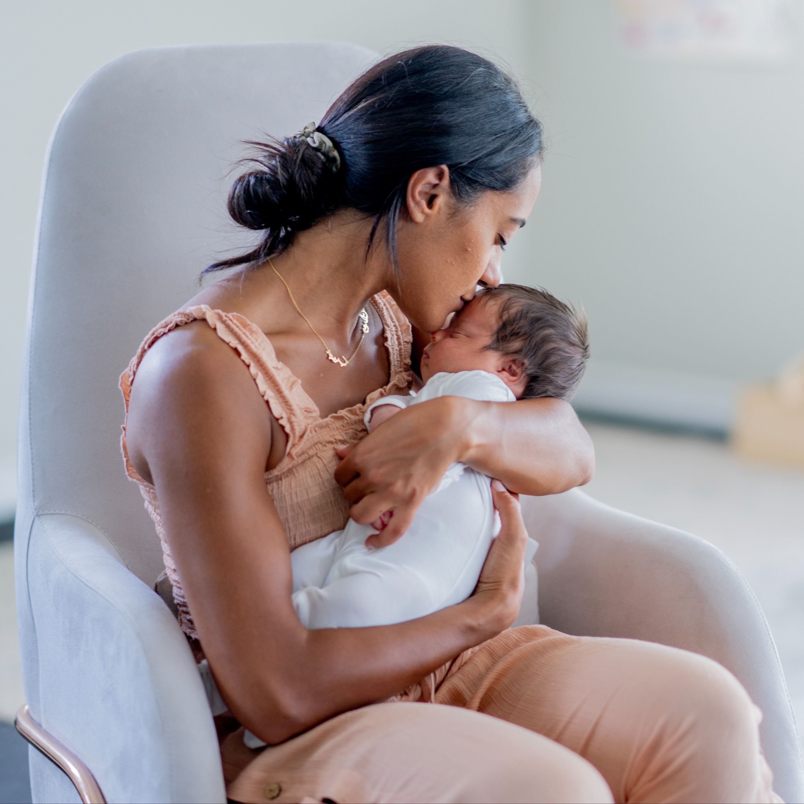 Newborn baby sleeping in mother's arms