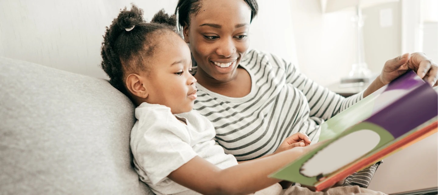 Preschooler reading in bed as part of the bedtime routine. | Huckleberry