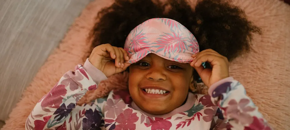 A young girl in pajamas smiling.
