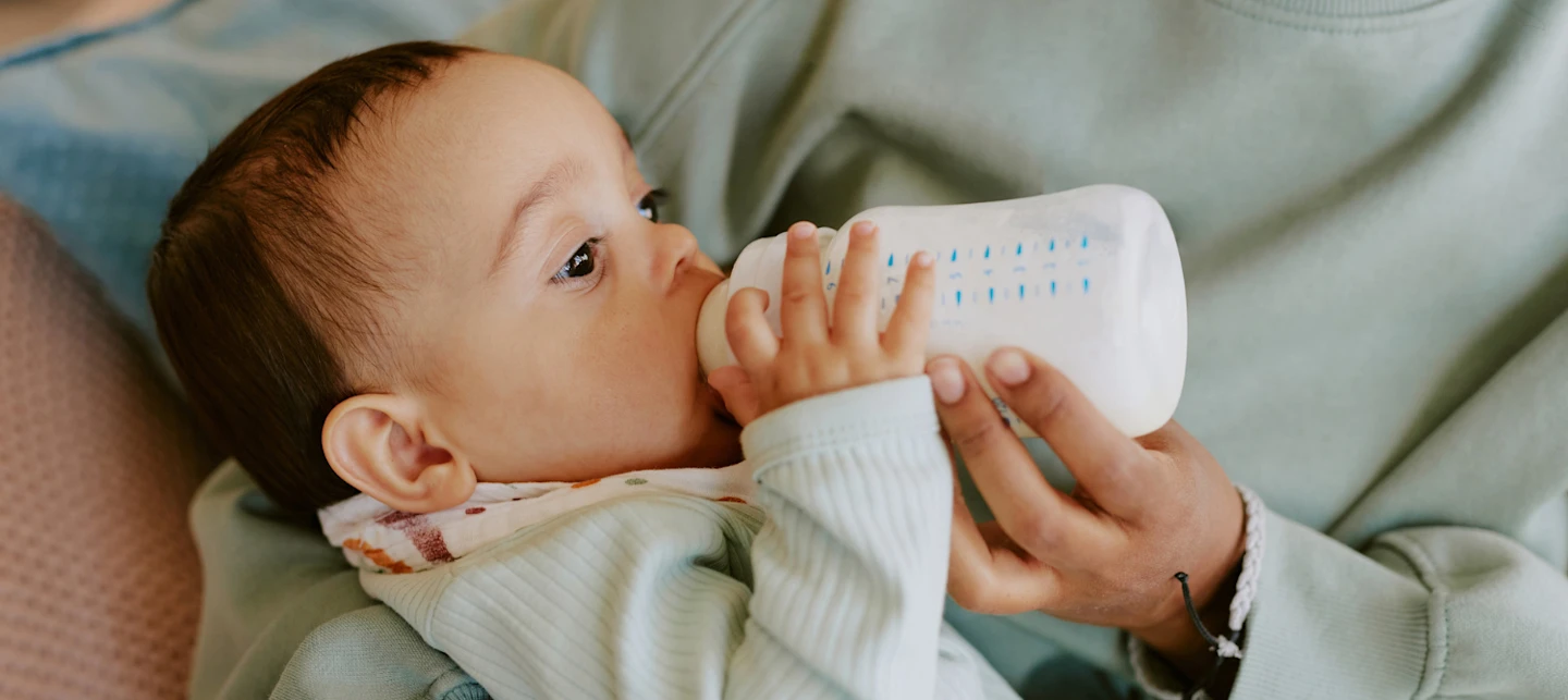 Baby drinking formula out of a bottle | Huckleberry
