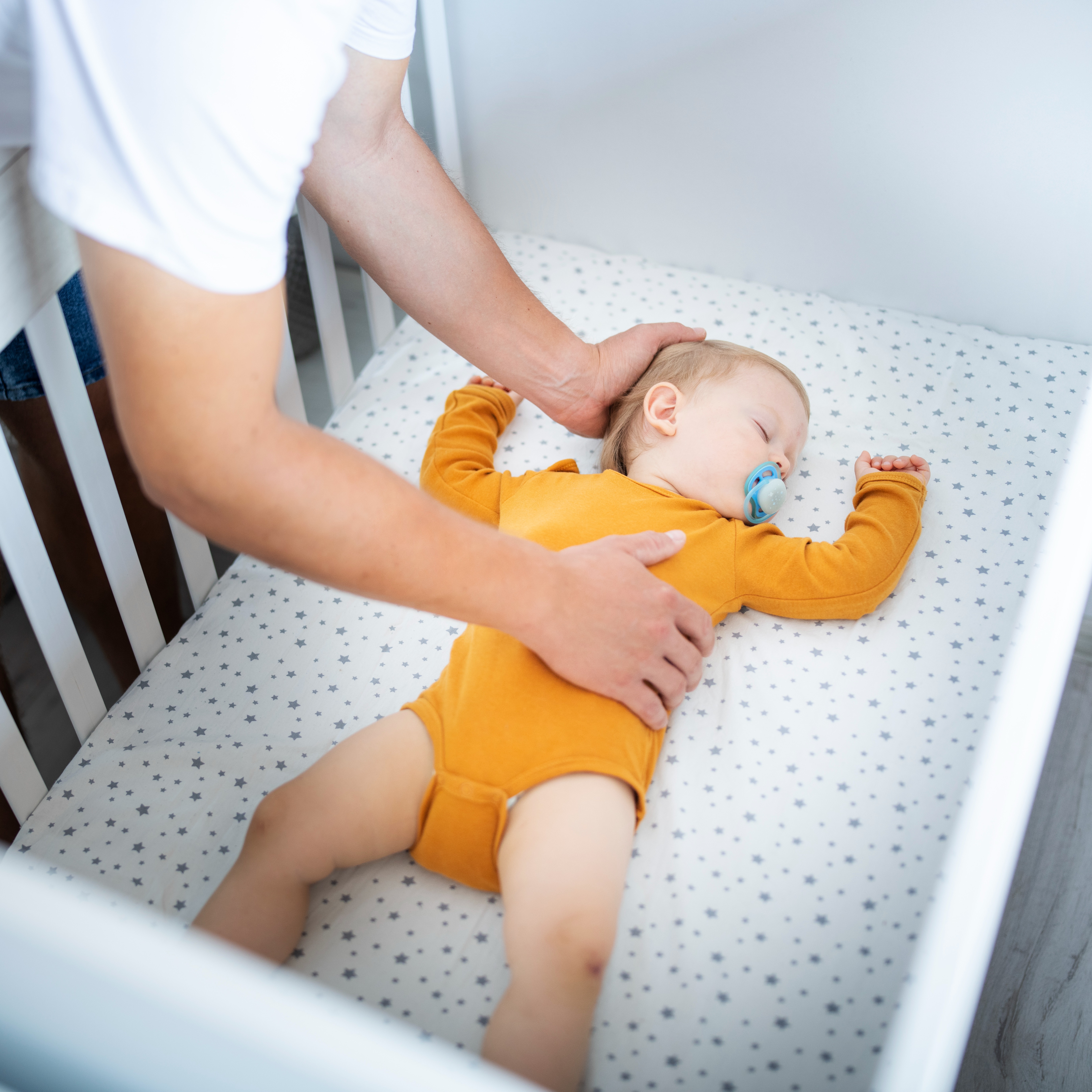 Baby sleeping with parent checking on them