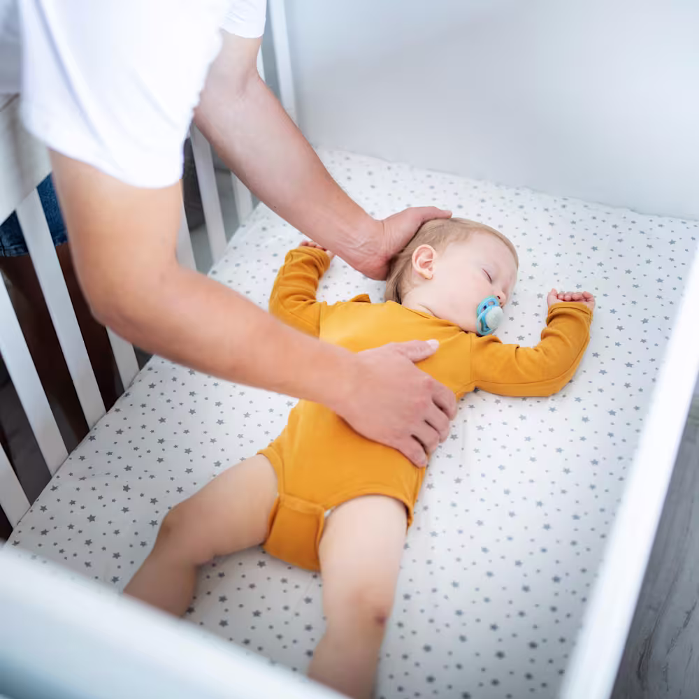 Baby sleeping with parent checking on them