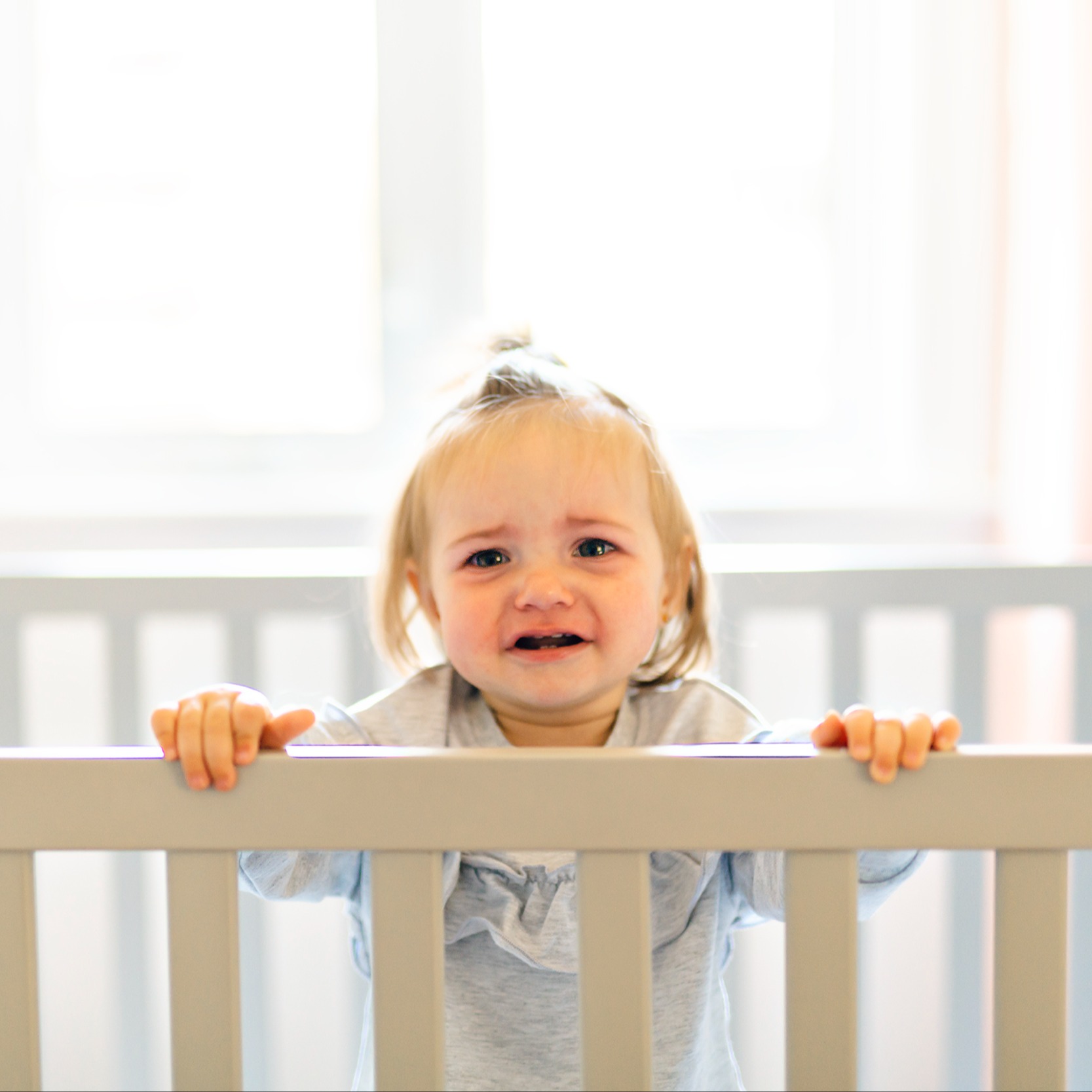 sad baby in crib