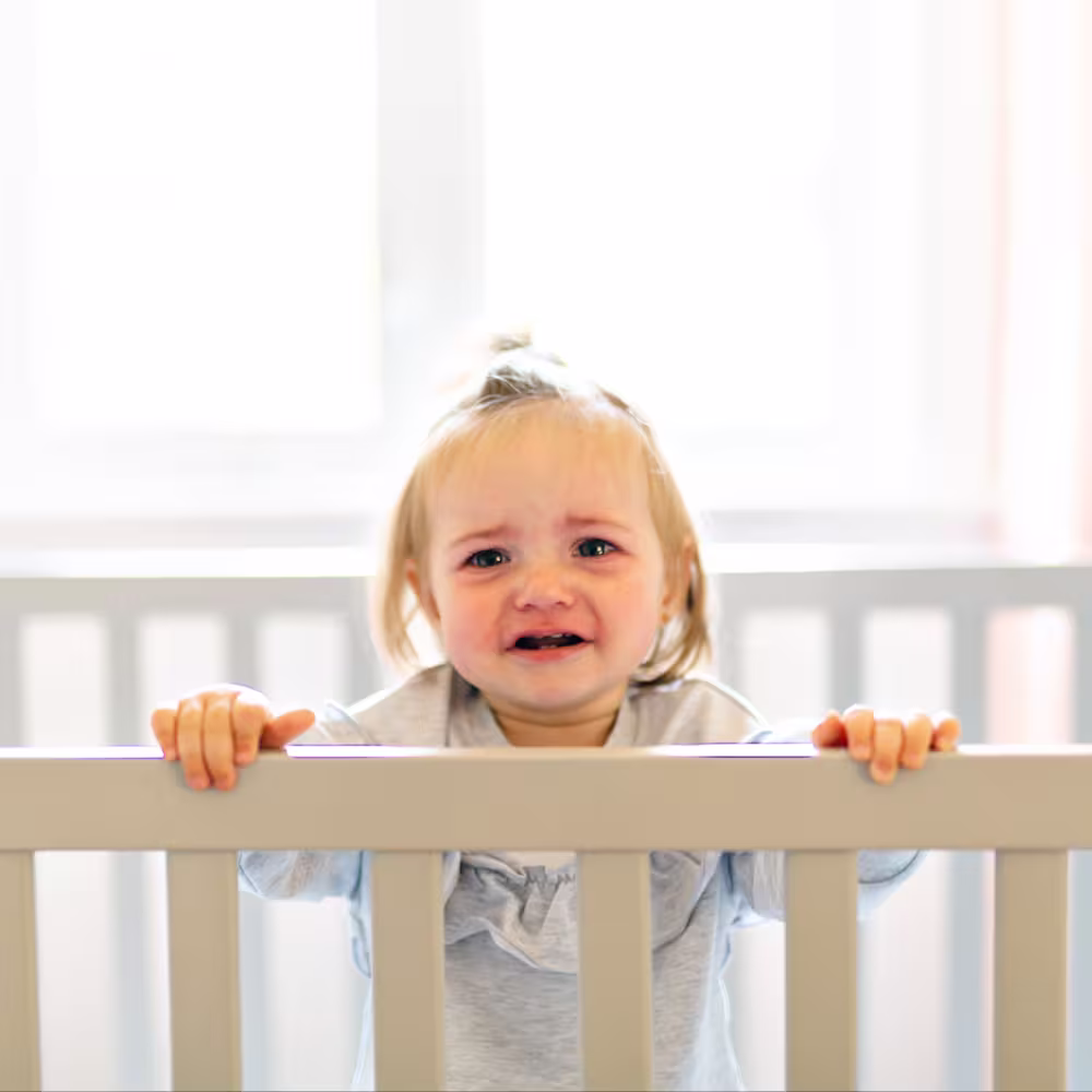 sad baby in crib