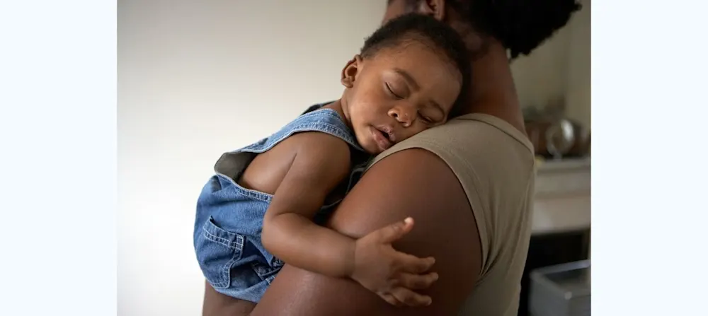 Baby sleeping in mother's arms