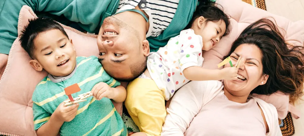 Two parents are laughing with their two children.