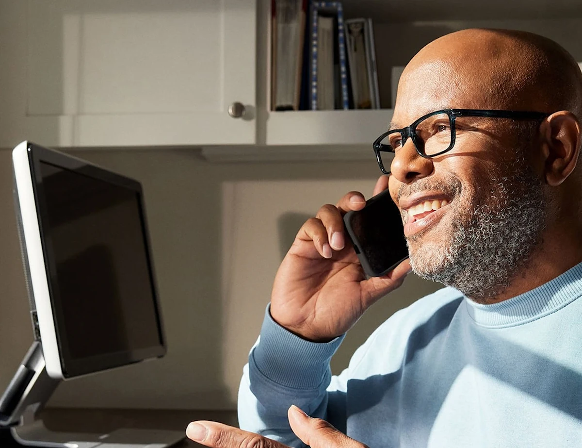 Man on phone looking at computer