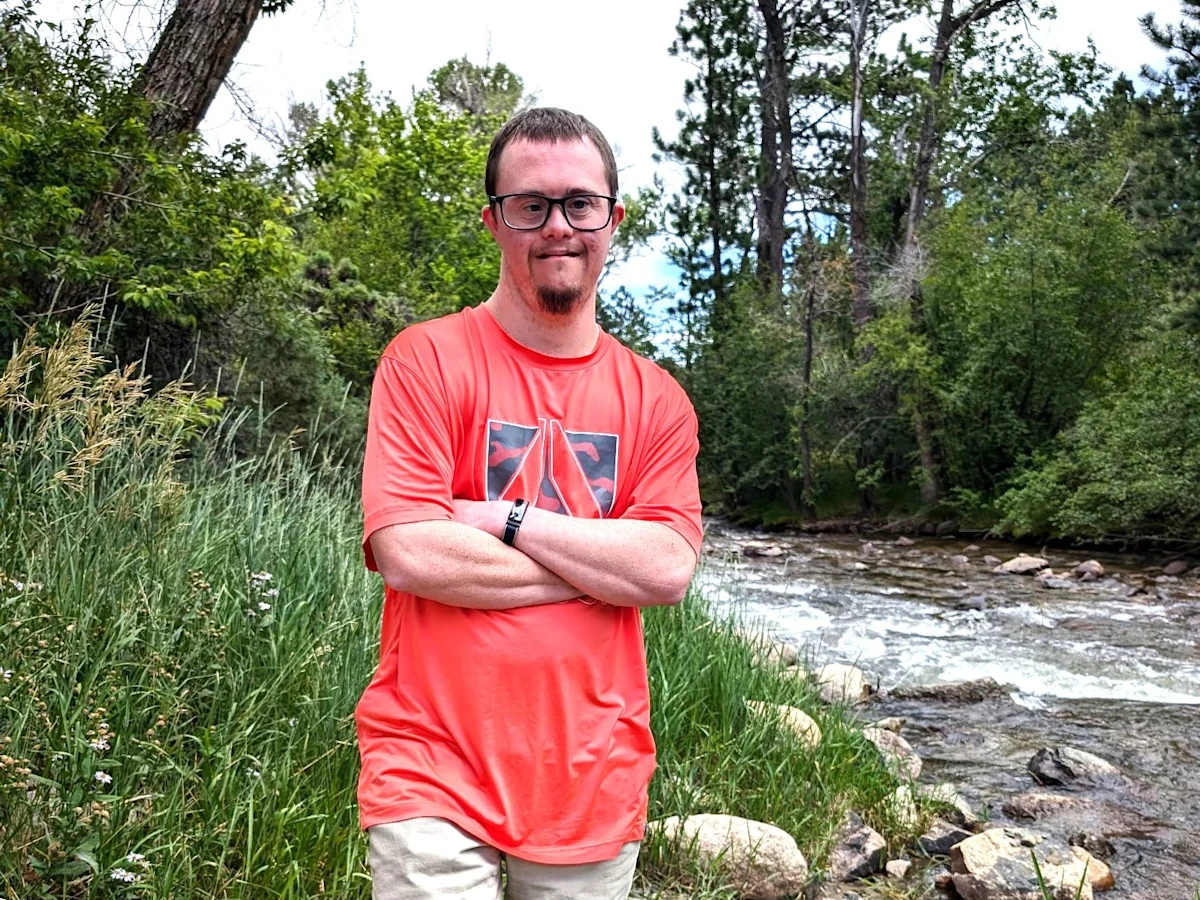 Travis Rice hikes by a stream. Travis has Down syndrome and obstructive sleep apnea (OSA). Since he started treating his OSA with Inspire® therapy, his mother said he is happier and more energetic.