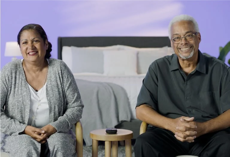 The image shows a smiling couple sitting together. 