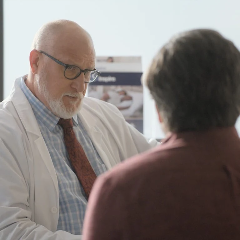 The image shows two people engaged in conversation.