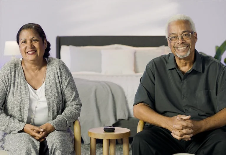 The image shows a smiling couple sitting together.