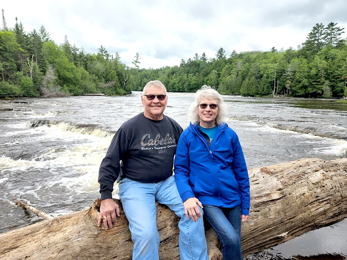 Linda Cole and her husband Mark sit down by a river in Michigan.