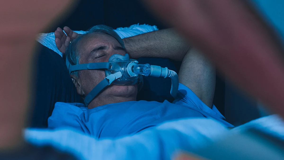 Man wearing a CPAP mask lies in bed at night