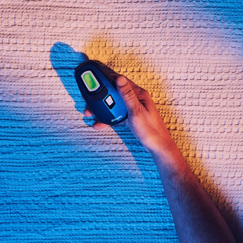 Image - Product - Remote Control in Hand Over Colorful Blanket - Mobile