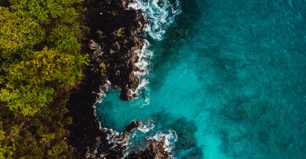 Blue ocean in tropics with rocky coast. Aerial view.