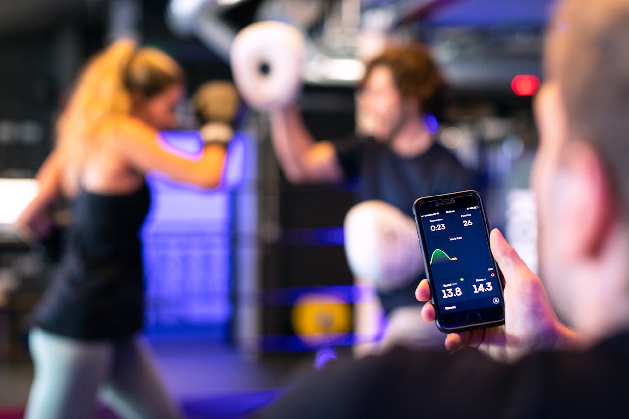 personal trainer holding a phone with a pt app open