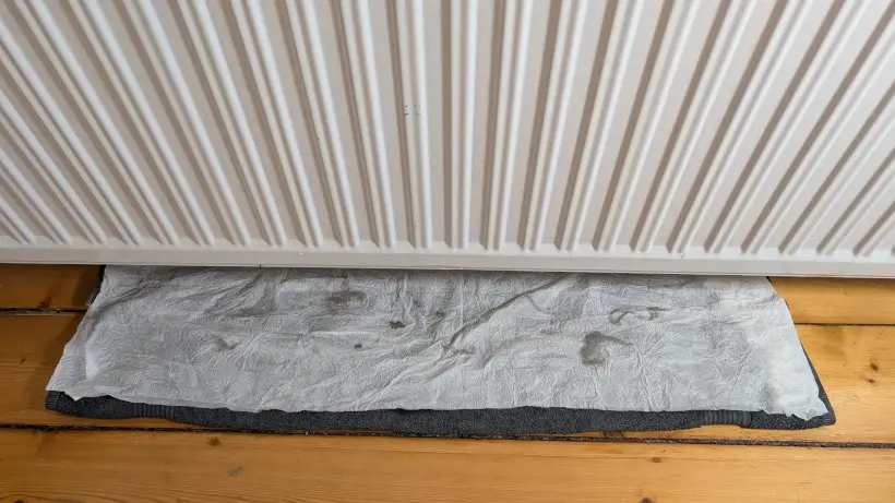 Čištění radiátorů, podložených hadrem na ochranu podlahy
