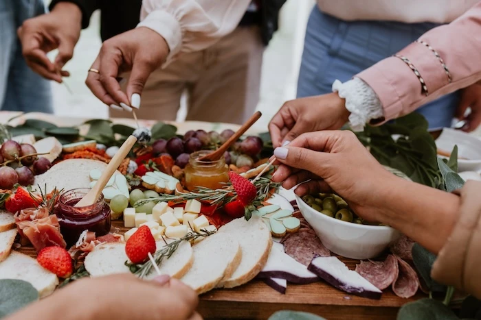 Schmuckbild: Charcuterie Board, von dem mehrere Personen essen.