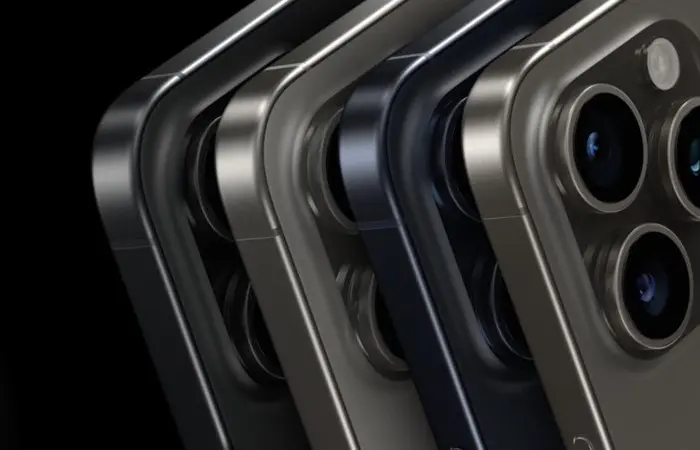 iPhone 15 Pro in den Farben Titan-Schwarz, Titan-Weiß, Titan-Blau und Titan-Natural in der Nahaufnahme