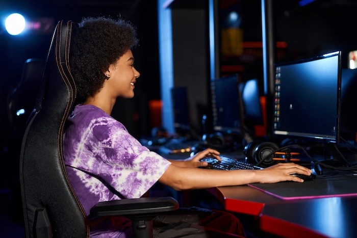 Mädchen sitzt auf Gaming-Stuhl vor dem PC
