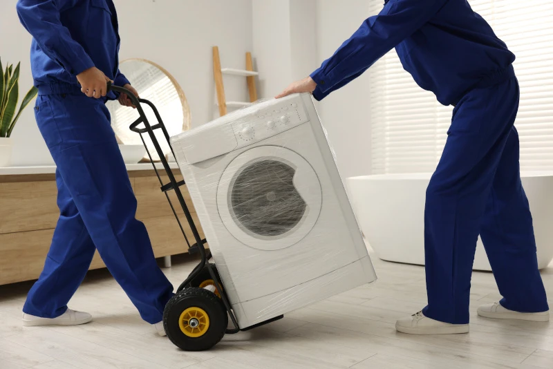 Waschmaschine mit zwei Personen transportieren
