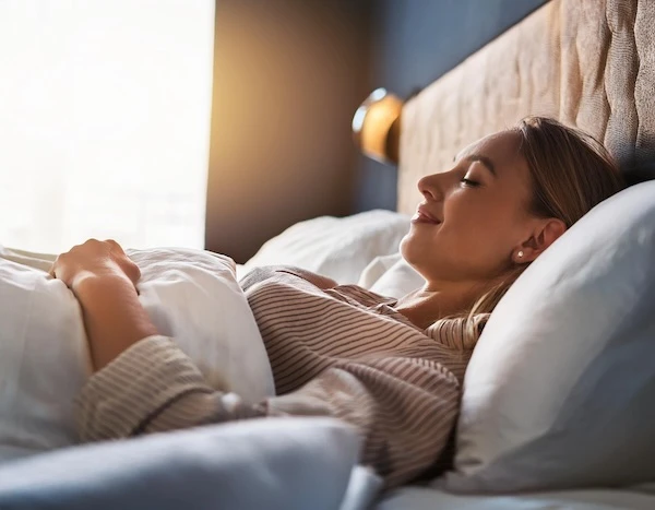 Frau liegt entspannt im Bett