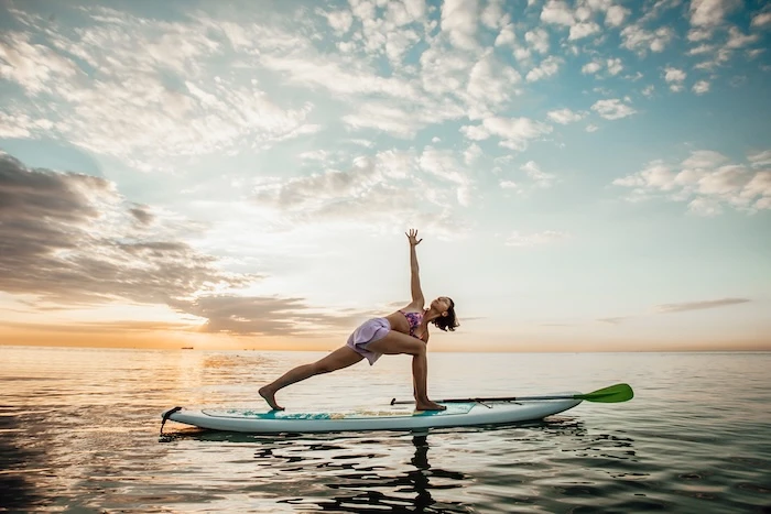 Schmuckbild: Eine Frau, die Yoga-Übungen auf einem Stand Up Paddle Board macht, das sich auf einem See befindet.