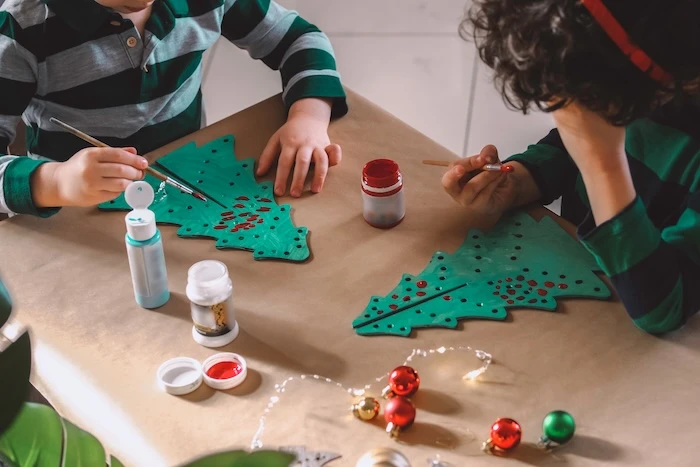 Kinder bemalen Tannenbäume aus Papier