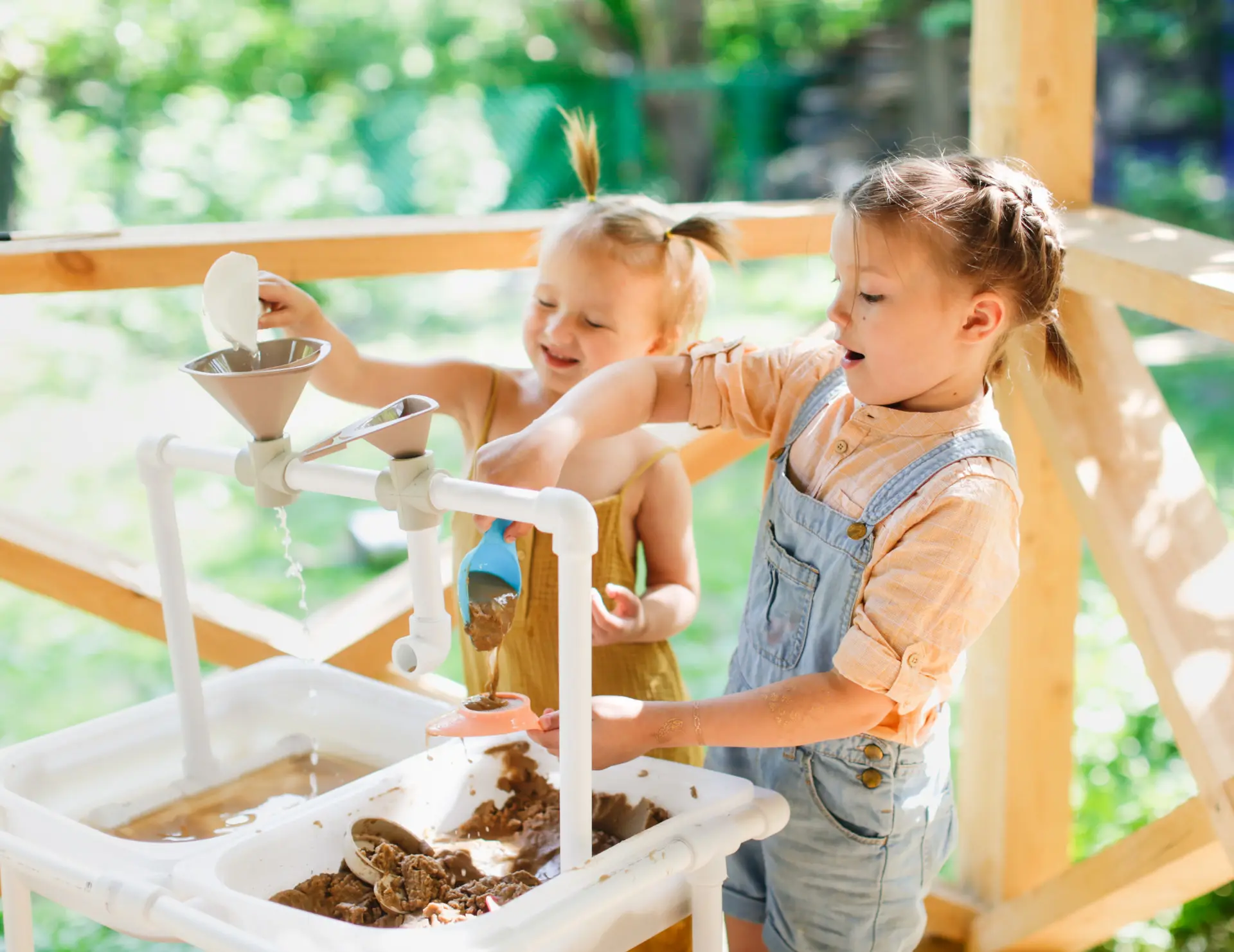 Zwei Kinder spielen mit Sand und Wasser