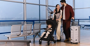 Werbung: Reisende Familie am Flughafen mit kompaktem Kinderkraft Buggy und Koffer für unterwegs.