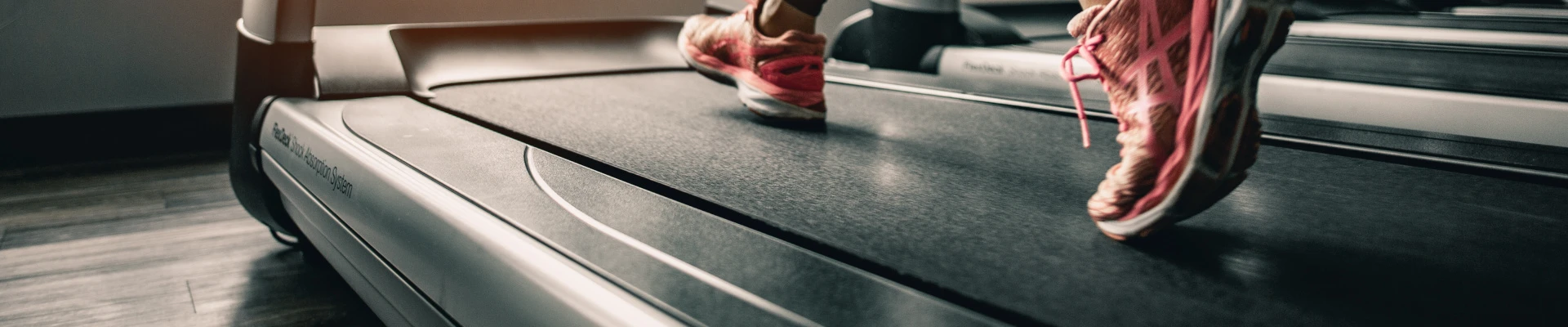 Schmuckbild: Person mit pinken Joggingschuhen läuft auf Laufband