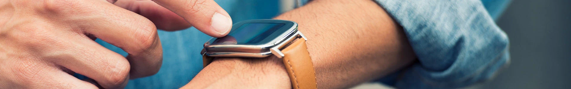 Schmuckbild: Mann tippt auf Smartwatch am Handgelenk ein