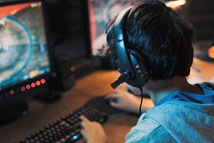 Gamer mit Headset beim Zocken vor PC-Setup