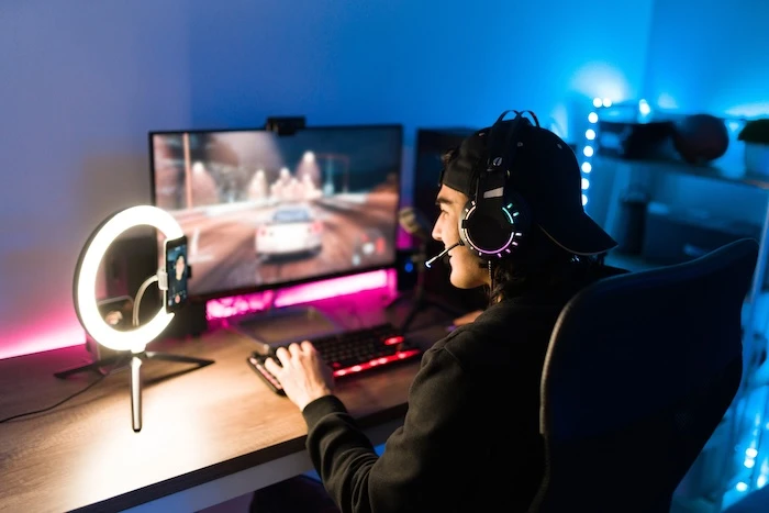 Gamer beim Zocken sitzt vor PC-Setup mit Ringlicht