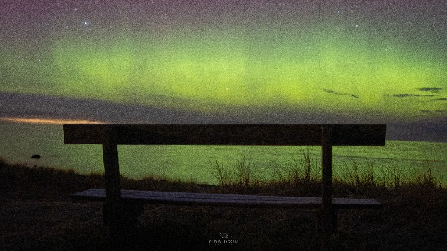 bænk ved strand i nordlys