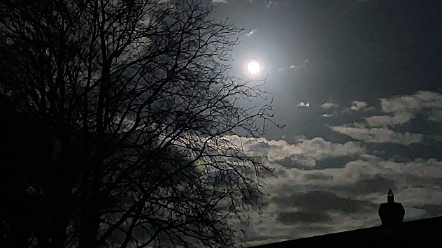 Full moon through gap in clouds