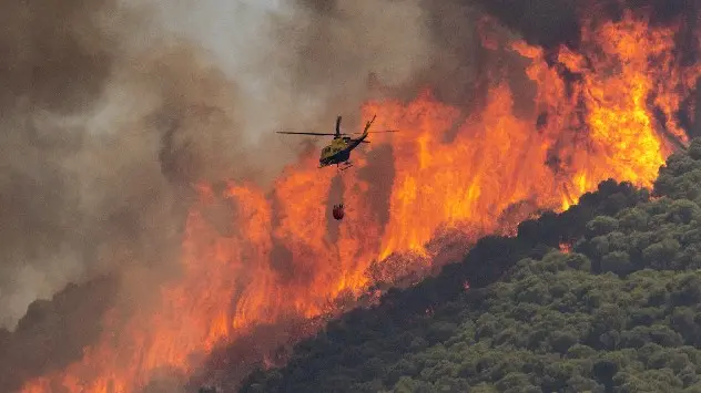  Вертоліт заливає водою полум'я лісової пожежі в Міхасі, Малага, Південна Іспанія