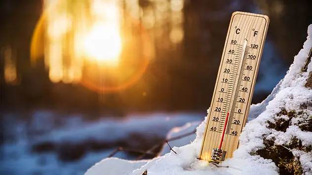 Zeitumstellung Frühling Eselsbrücken Thermometer steckt im Winter im Schnee