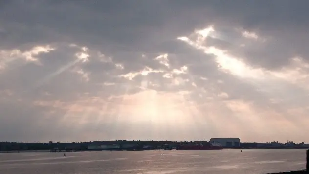 Rays of light stream between cloud cover in Liverpool