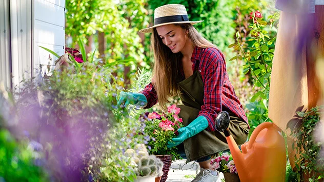 Junge Frau arbeitet im Garten und bepflanzt Beete