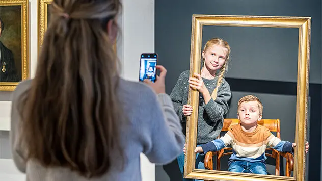 Mutter fotografiert ihre Kinder im Museum