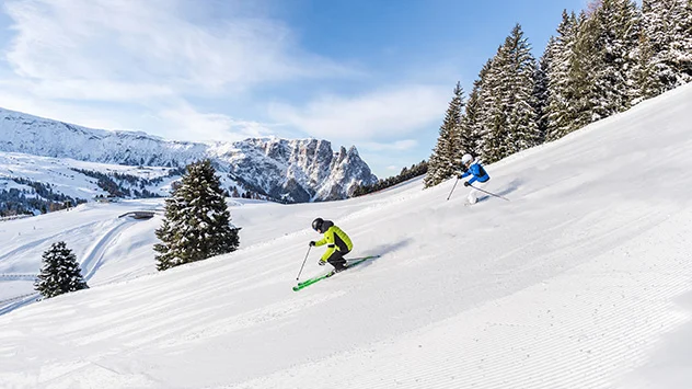 Sonnenskilauf in der Dolomitenregion Seiser Alm - Bild: IDM Südtirol / Harald Wisthaler Skifahrer auf einer Piste bei strahlendem Sonnenschein