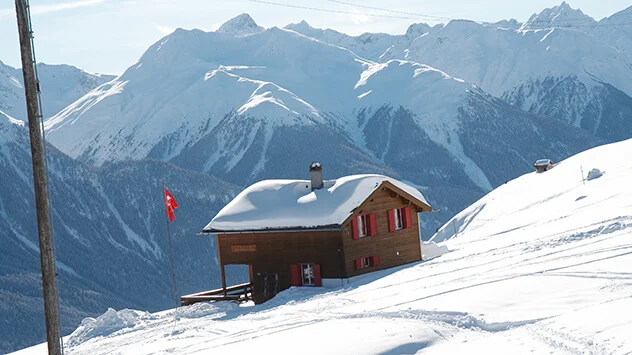 Verschneite Hütte im Skigebiet Motta Naluns