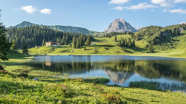 Blick über den ruhigen Körbersee und die grünen Berge