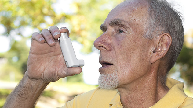 Mann hält Asthmaspray in der Hand