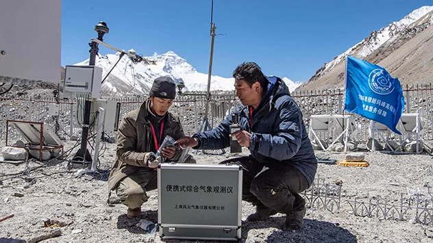 zwei Männer bauen eine vollautomatisierte Wetterstation in Tibet in China auf